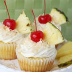 pina colada cupcake with cream cheese frosting and cherry on top