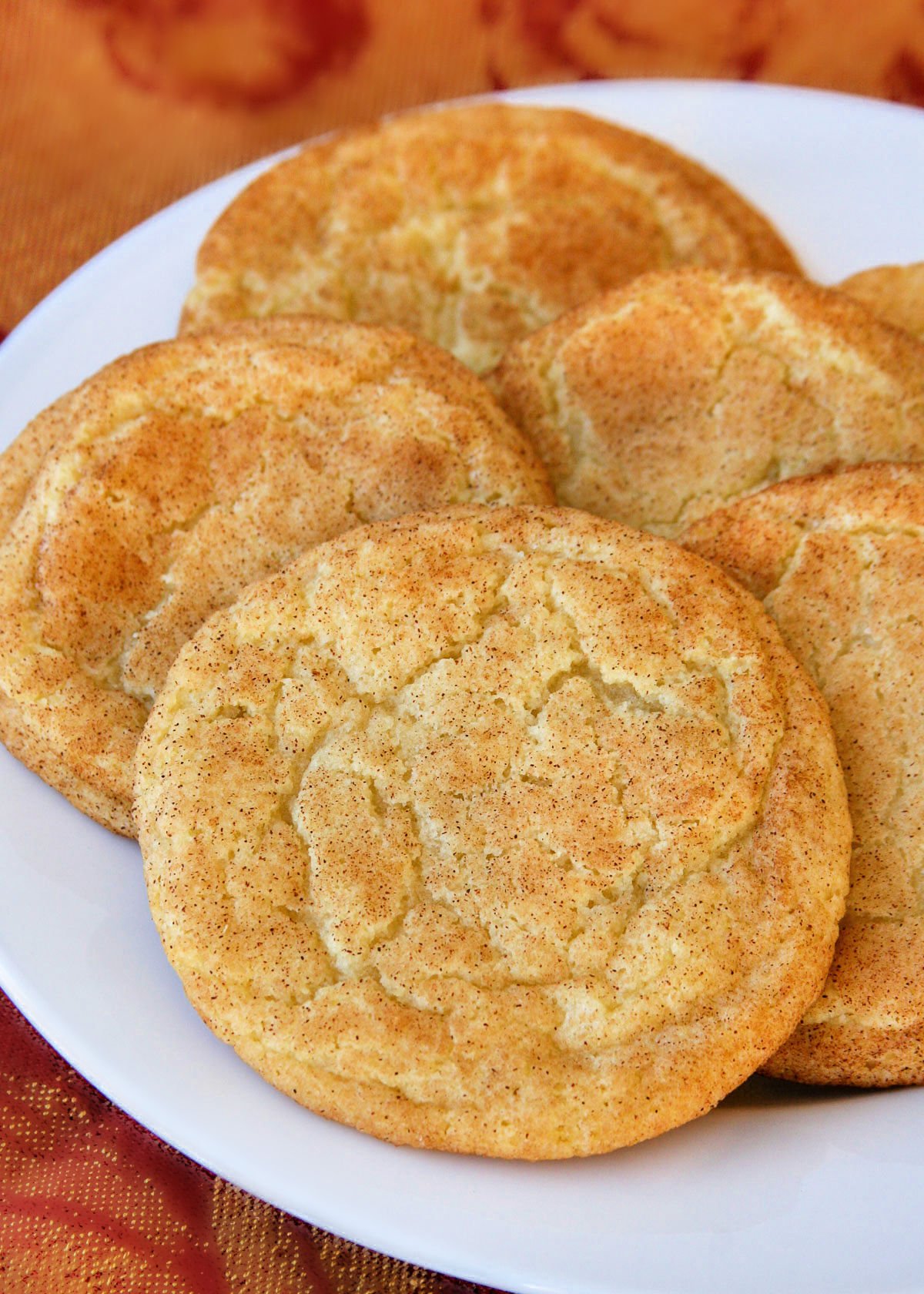 snickerdoodles on white plate with thanksgiving fabric underneath the plate