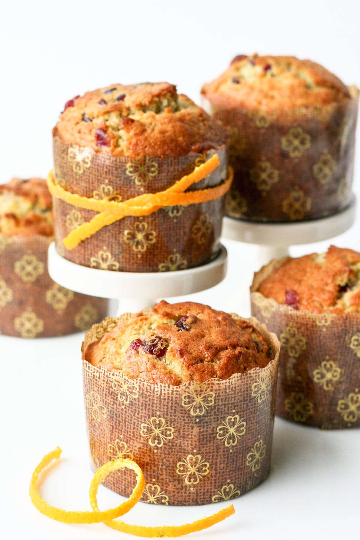 4 cranberry orange muffins on white surface