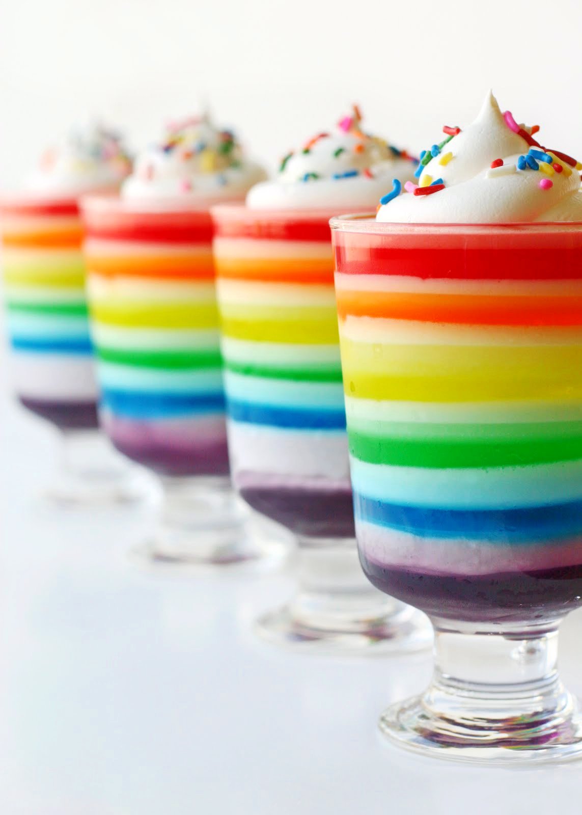 rainbow jello in tall glasses lined up in a row