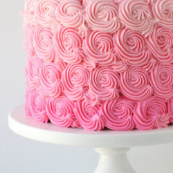 pink ombre cake on a white cake stand