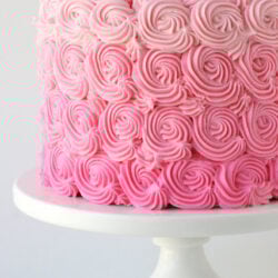 pink ombre cake on a white cake stand