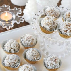 Coconut Snowballs on a white surface, with some on a glass cake stand.
