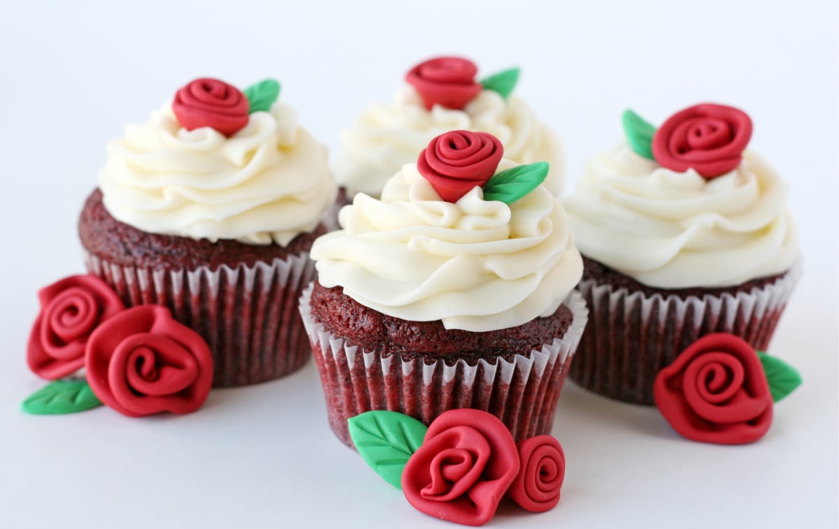 four red velvet cupcakes on a white backgorund