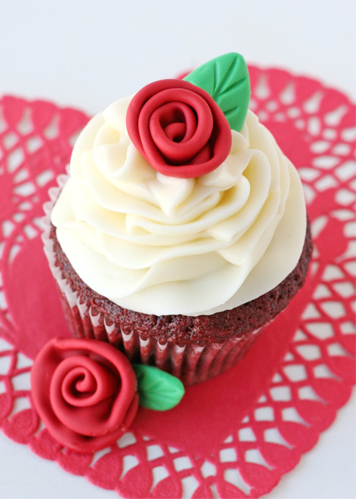 red velvet cupcakes on white background with red fondant roses