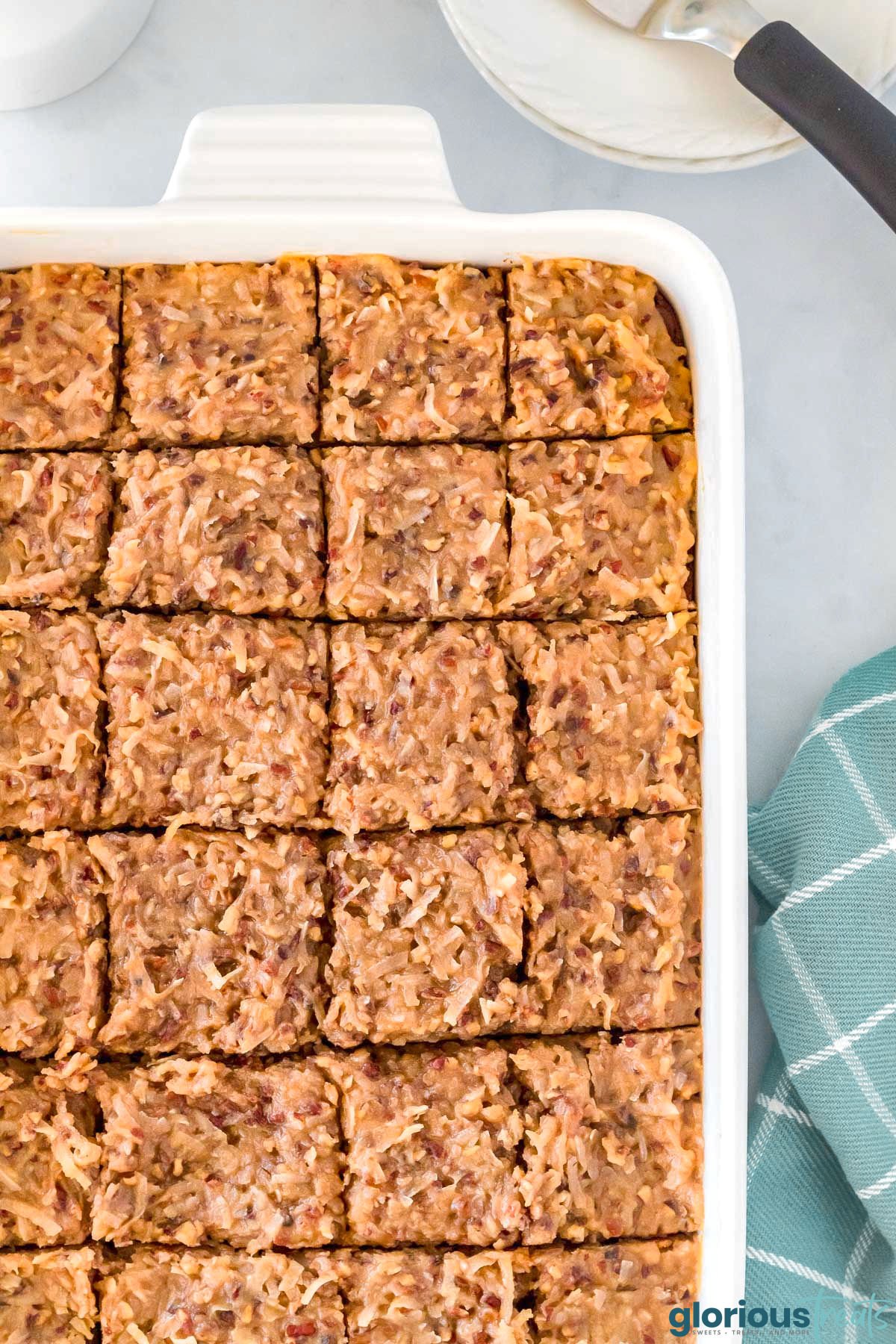 top down view of frosted german chocolate brownies in white baking dish already cut up and ready to serve.