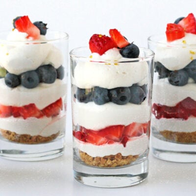 no bake trifle in three glasses layered with berries and cream.