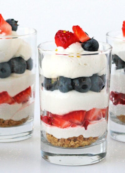 no bake trifle in three glasses layered with berries and cream.