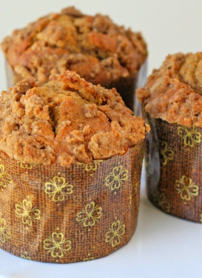 three pumpkin muffins recipe with cinnamon streusel on white cake stand