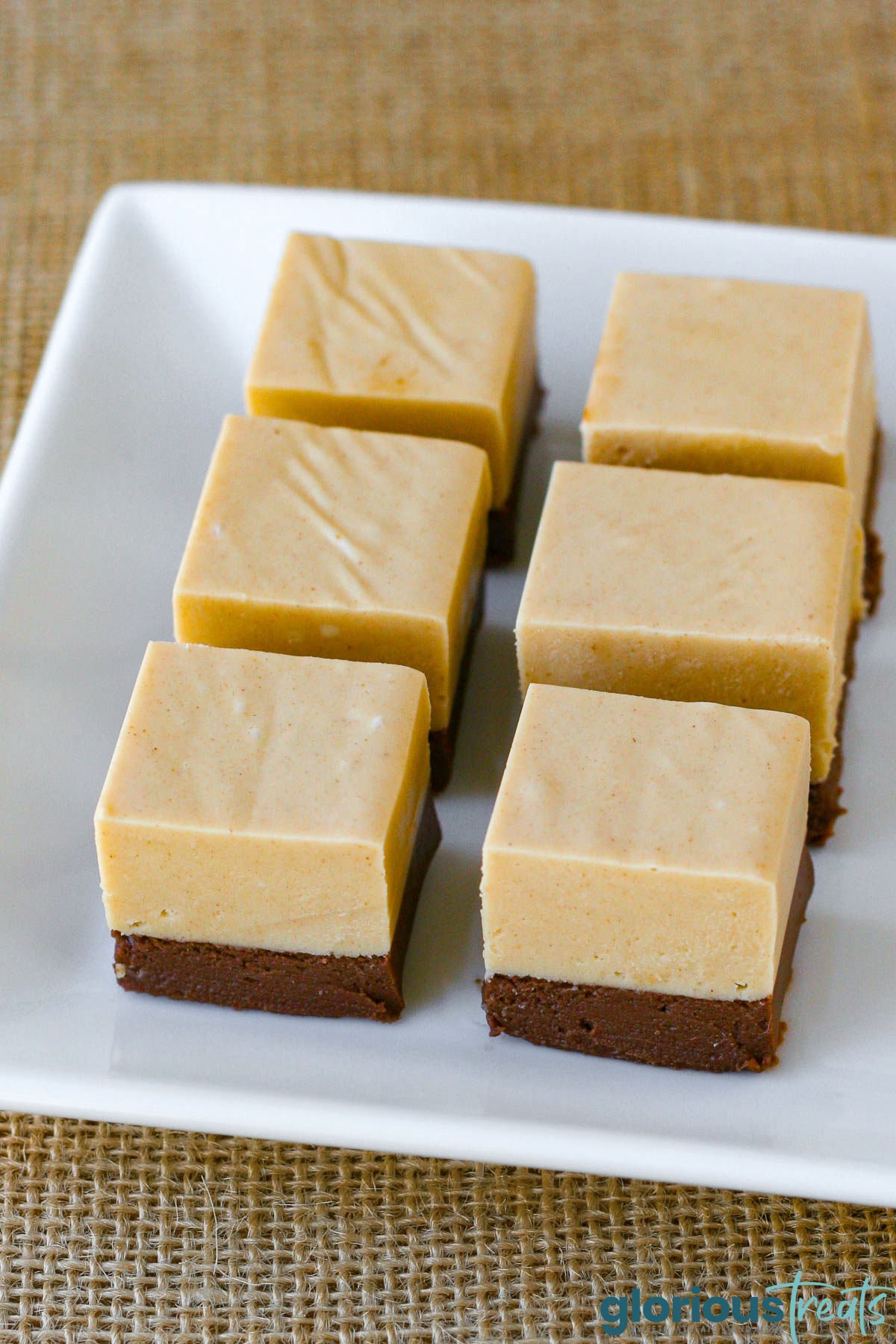 six pieces of chocolate peanut butter fudge on a white tray.