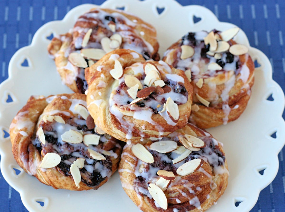 pastries made with puff pastry, cream cheese and blueberry jam drizzled with a glaze and sliced almonds sprinkled on top. 