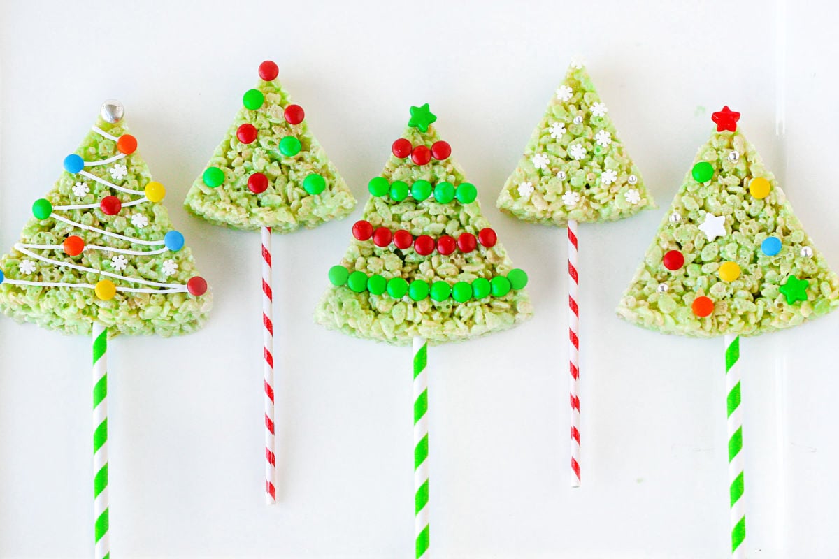 5 decorated rice krispie treat christmas trees on white background.