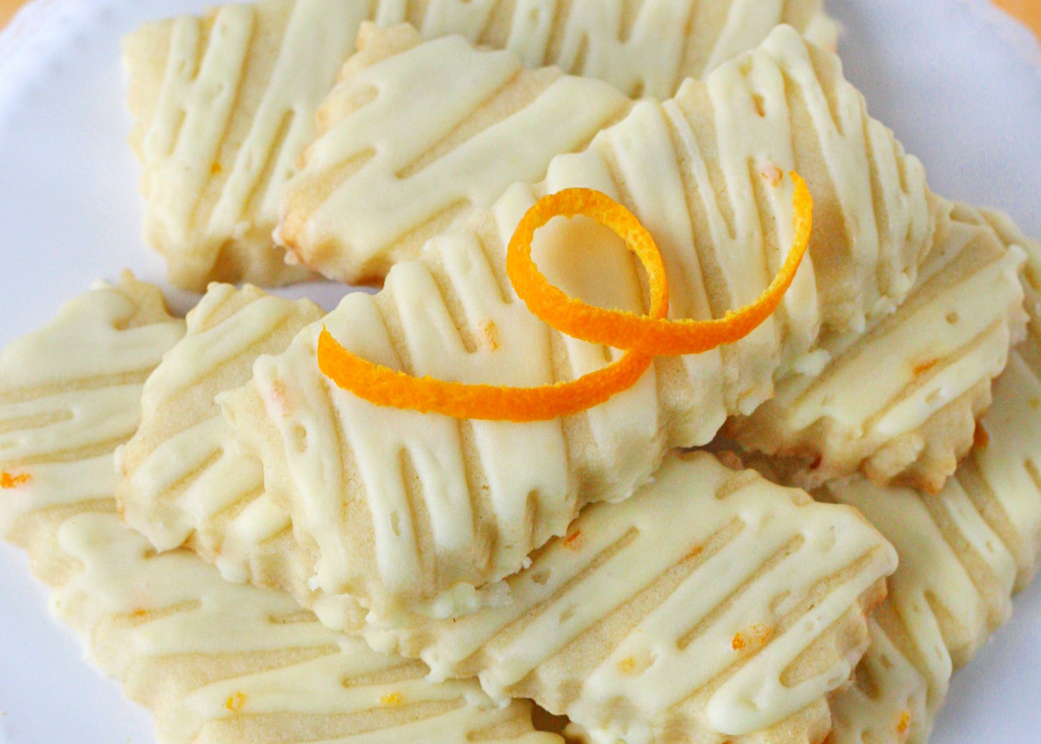 close look at orange sugar cookies with an orange glaze.