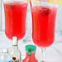 two punch glasses filled with bright pink party punch and topped with a lemon slice and fresh raspberry. punch ingredients shown at the bottom of the image and text overlay at the top.