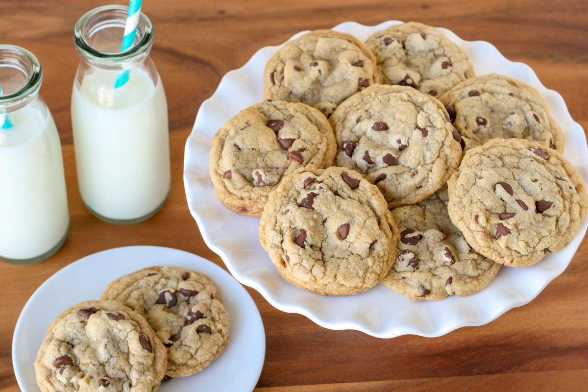 chocolate chip cookies on cake stand and on white plate on table top surface