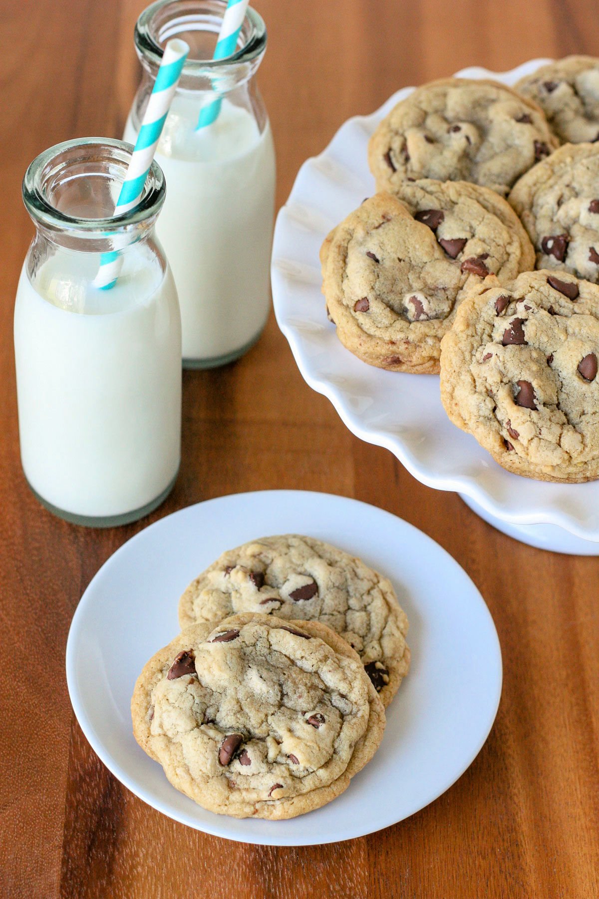 chocolate chip cookies on plate and cake stand with milk bottles in back