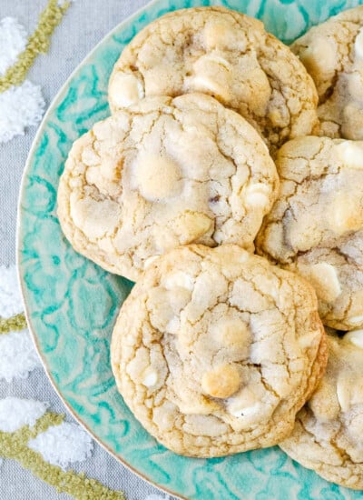 wide look at plate of cookies with a napkin with a bird on it beneath the plate