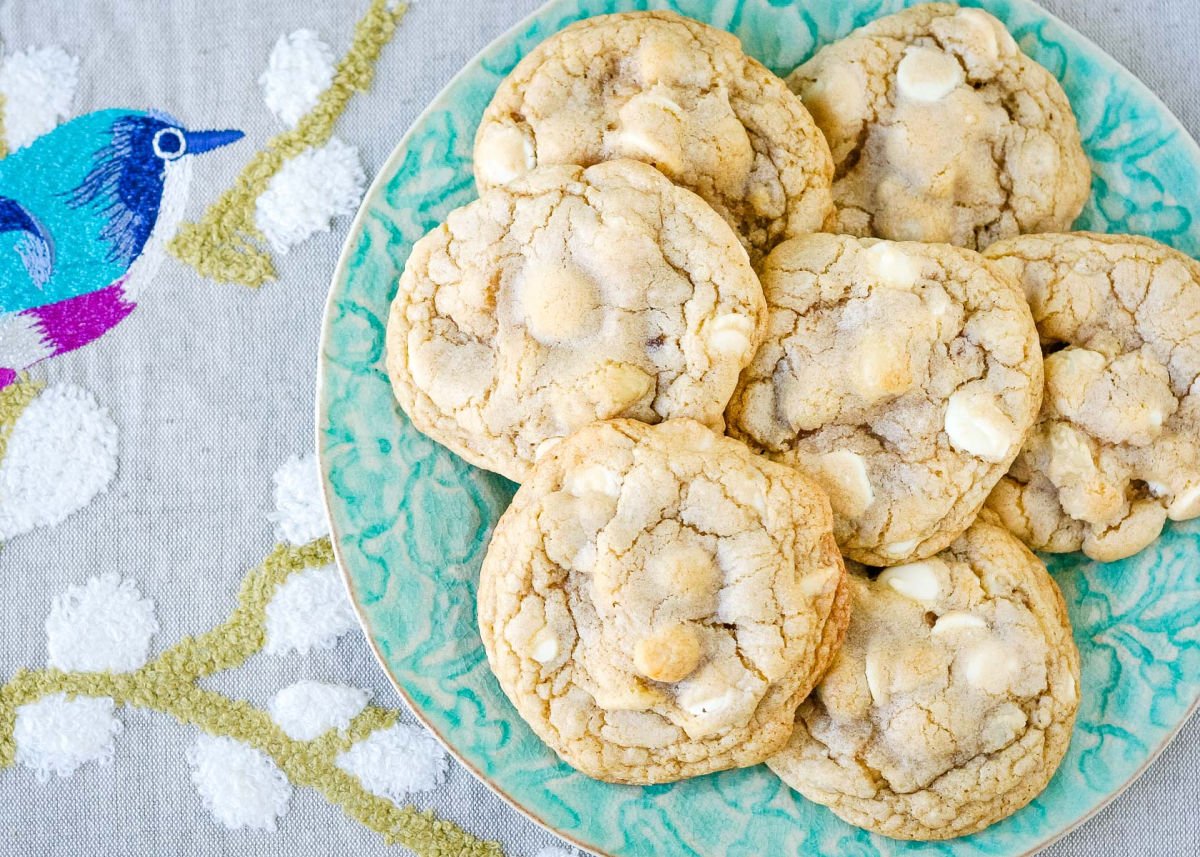 wide look at plate of cookies with a napkin with a bird on it beneath the plate