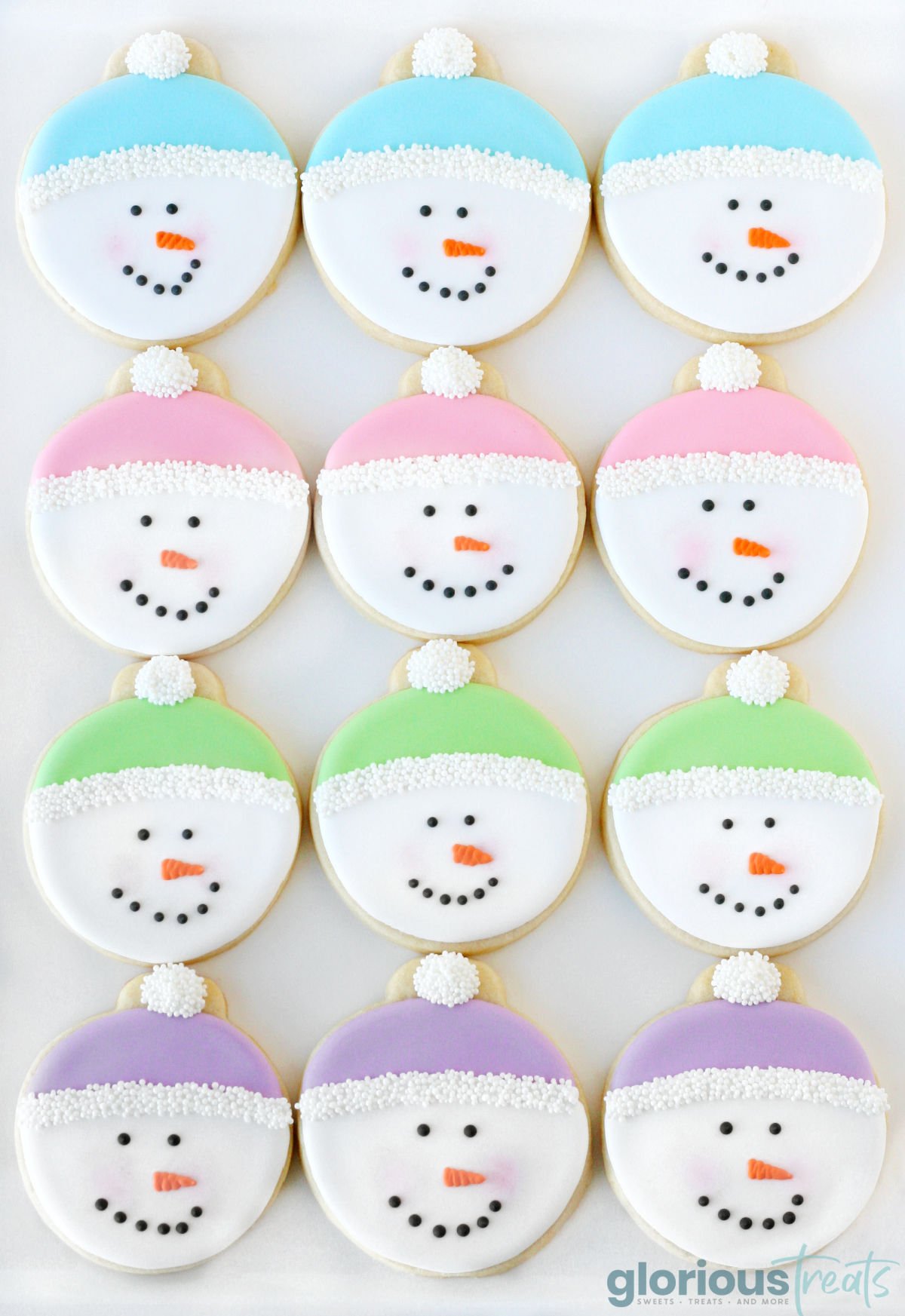 twelve snowman face cookies decorated with royal icing in four pastel colors. 