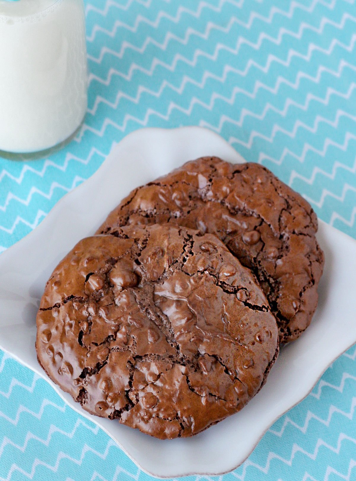 2 chocolate cookies on small white square plate