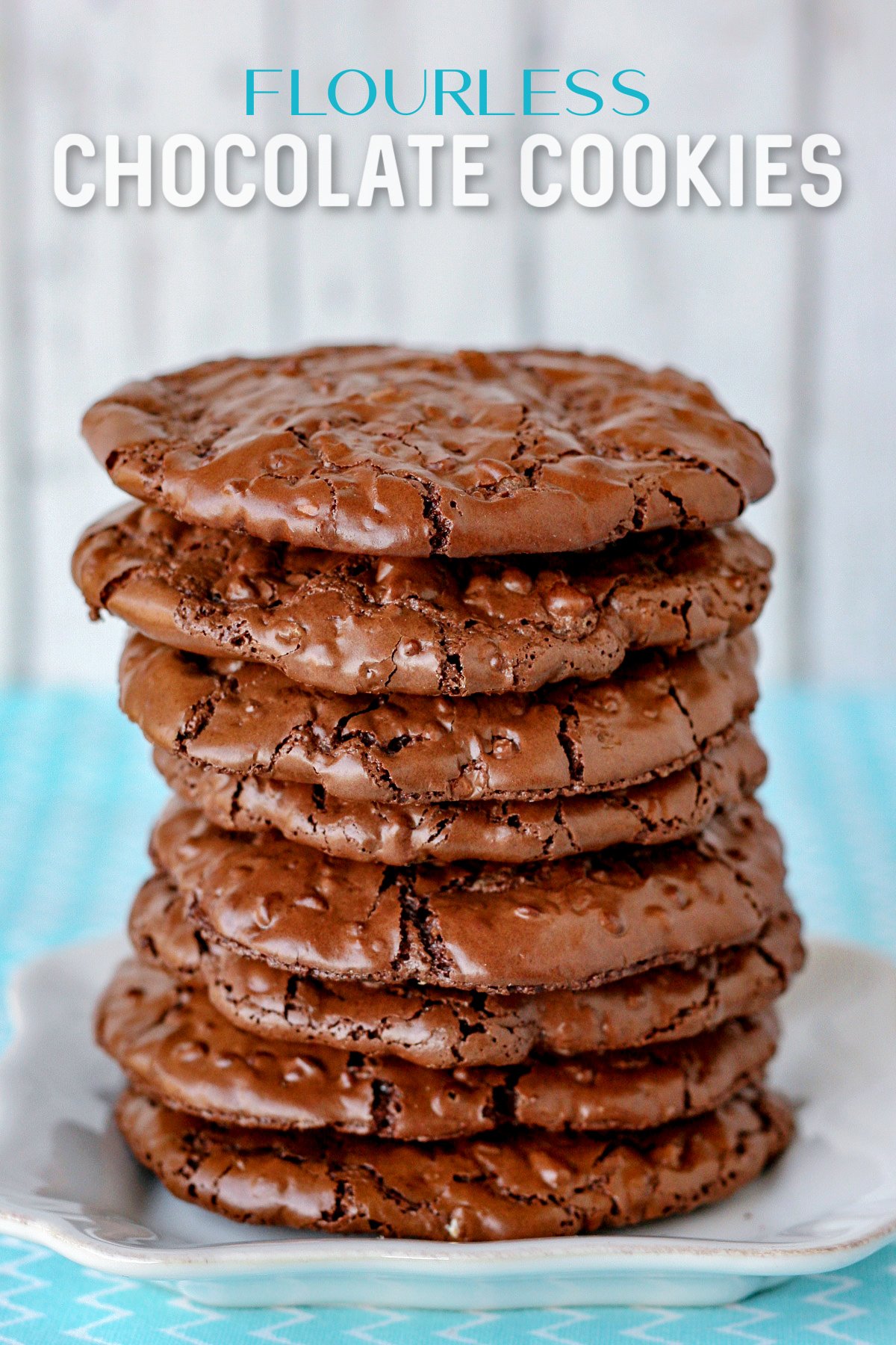 flourless chocolate cookies stacked tall on white plate with text overlay