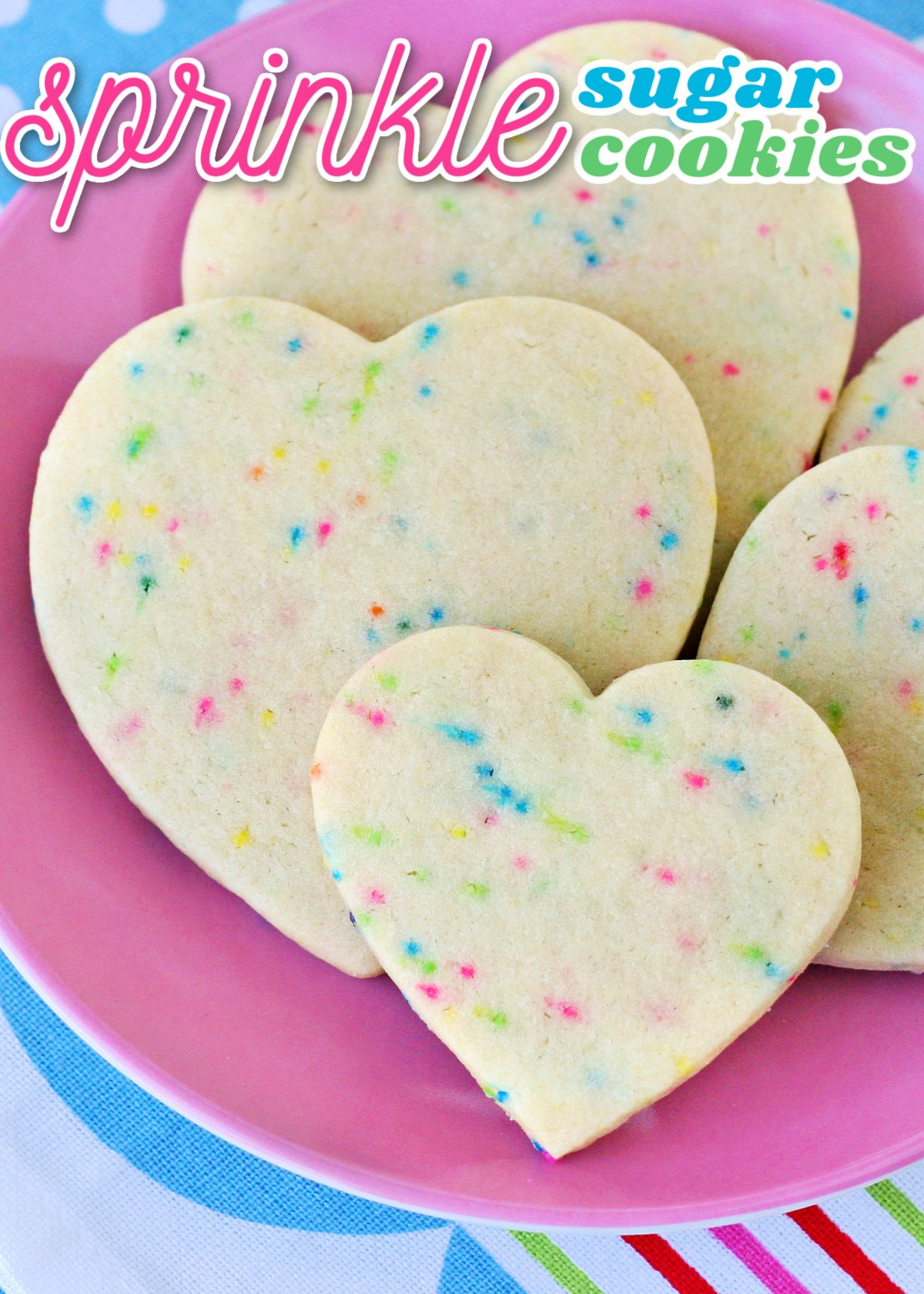 sugar cookies with sprinkles cut into heart shapes on pink plate with title overlay at top of image