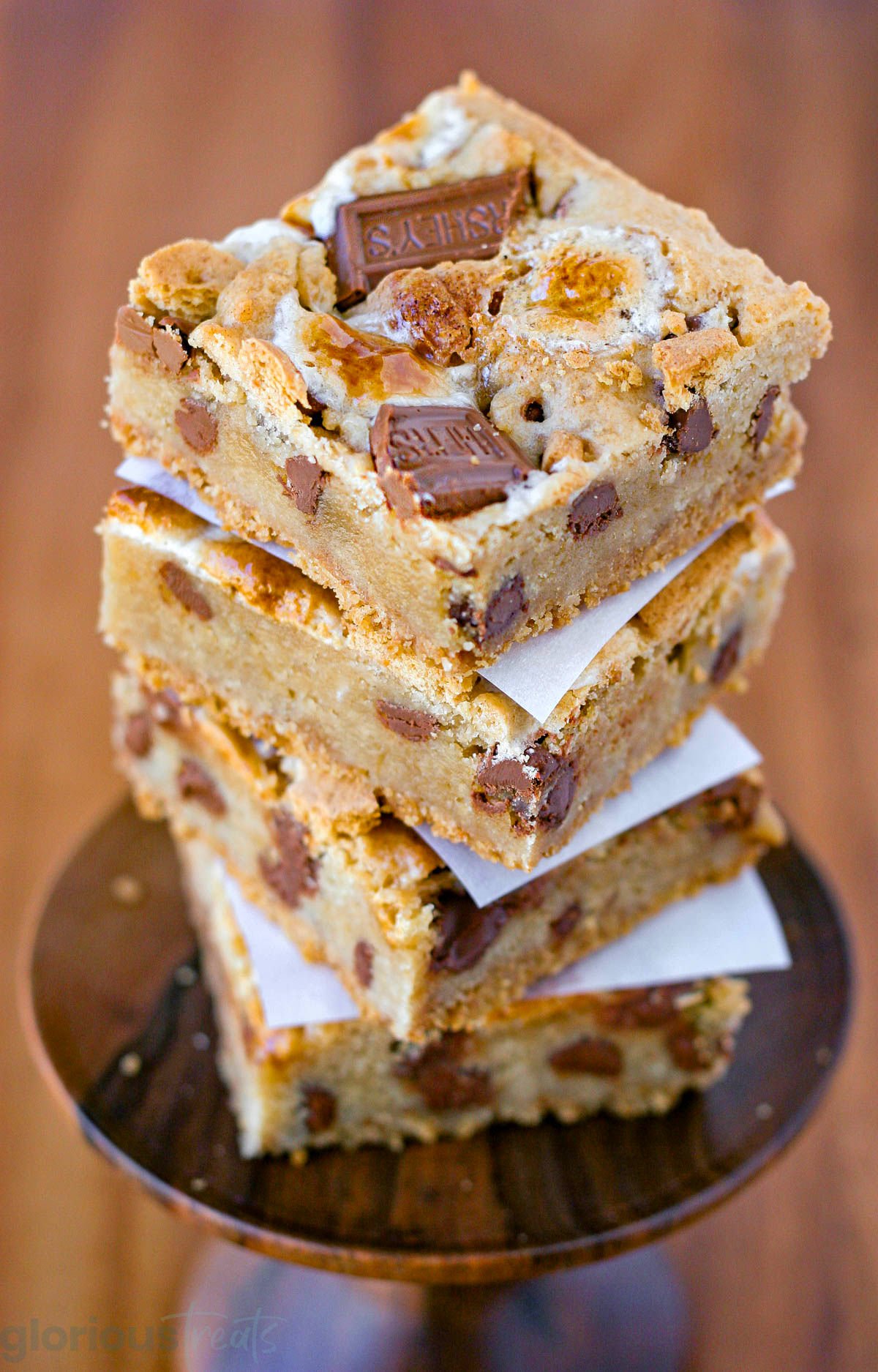 Stack of four smore bars on cupcake stand.