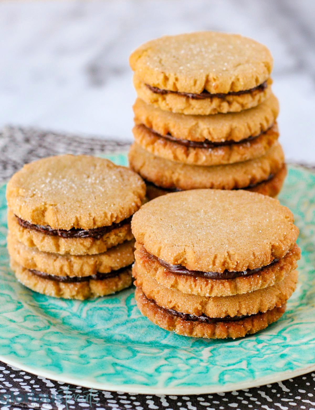 three stacks of peanut butter cookie sandwiches with chocolate ganache filling.