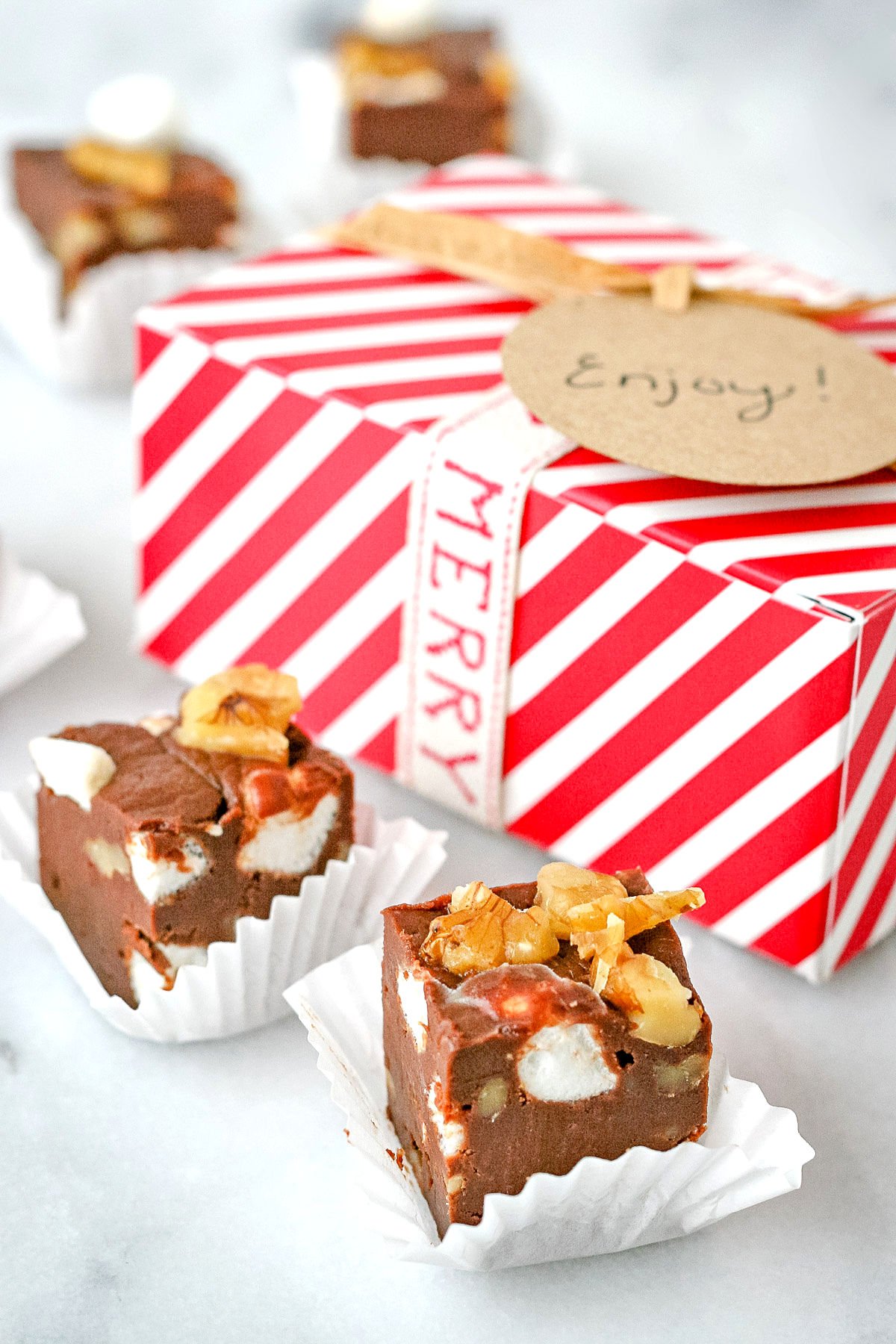 rocky road fudge pieces in white liners with red and white striped box in background