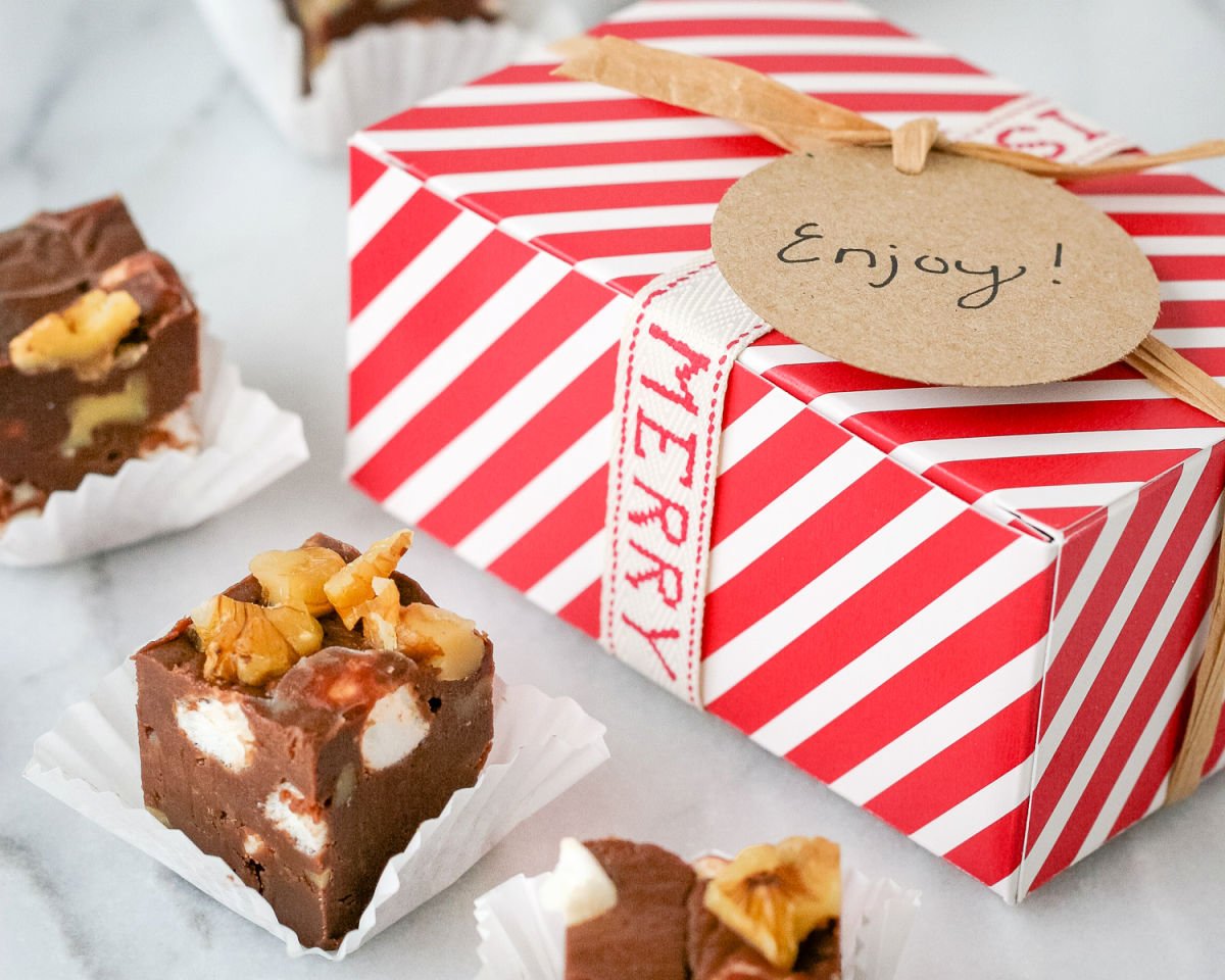 three squares of fudge sitting in front of gift box