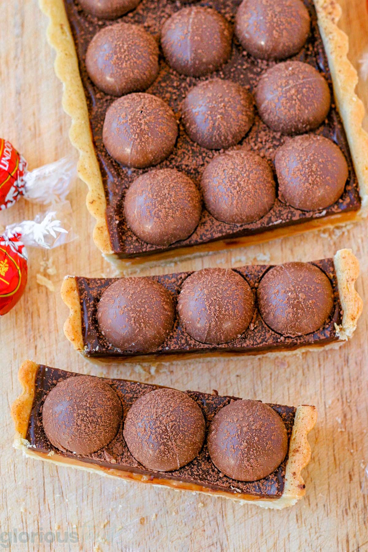 top down view of caramel chocolate tart with two pieces cut off the tart.