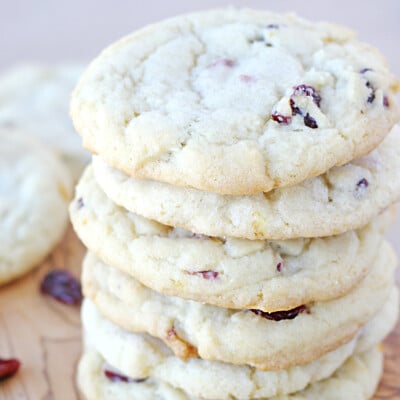 cranberry orange cookies stacked on a wood board