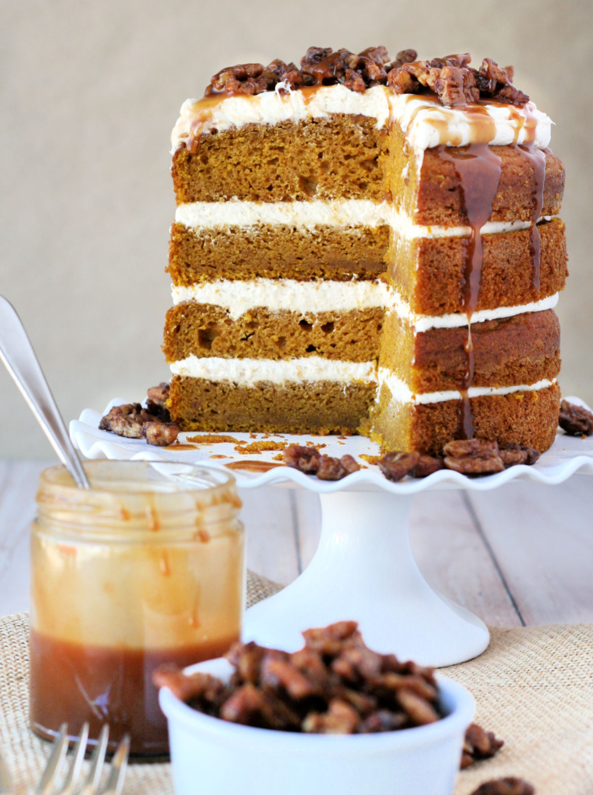 interior of pumpkin cake shown on white cake stand with slice removed