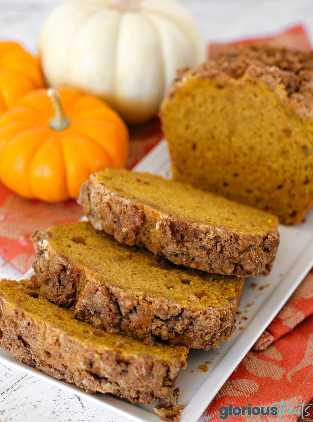 Slices of pumpkin bread on white tray with the rest of the left uncut.