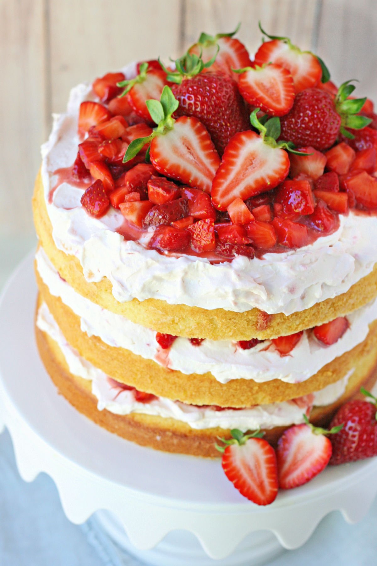 top down view of strawberry shortcake cake on white metal cake stand