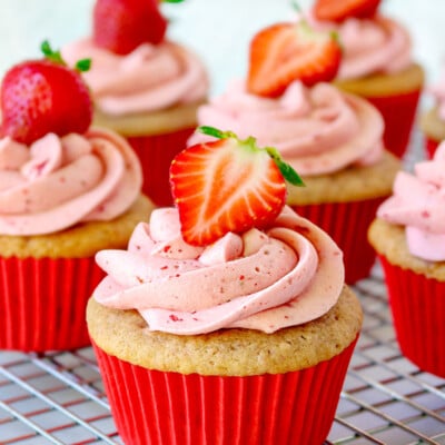 strawberry cupcake recipe on cooling rack with strawberry frosting and title overlay