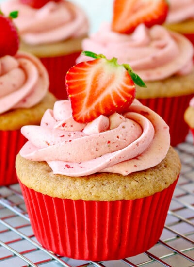 strawberry cupcake recipe on cooling rack with strawberry frosting square