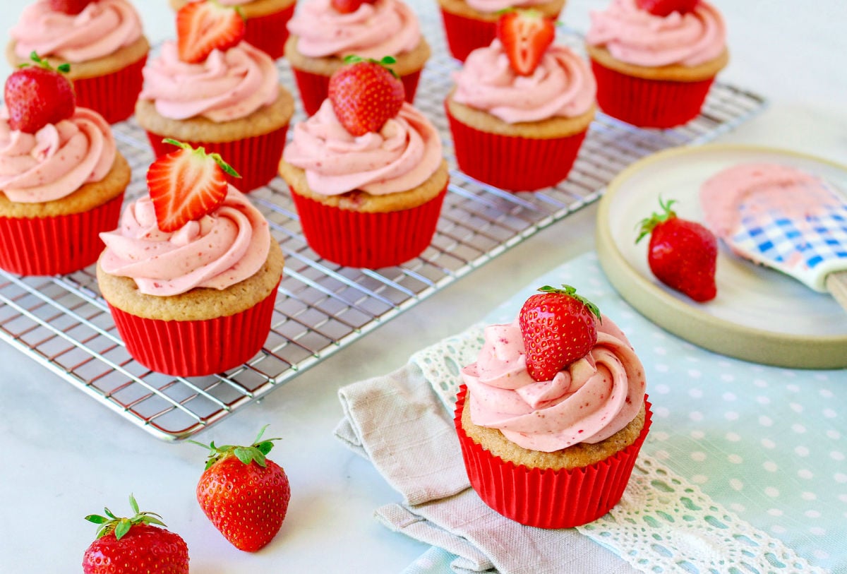 strawberry cupcakes on cooling rack with one plate