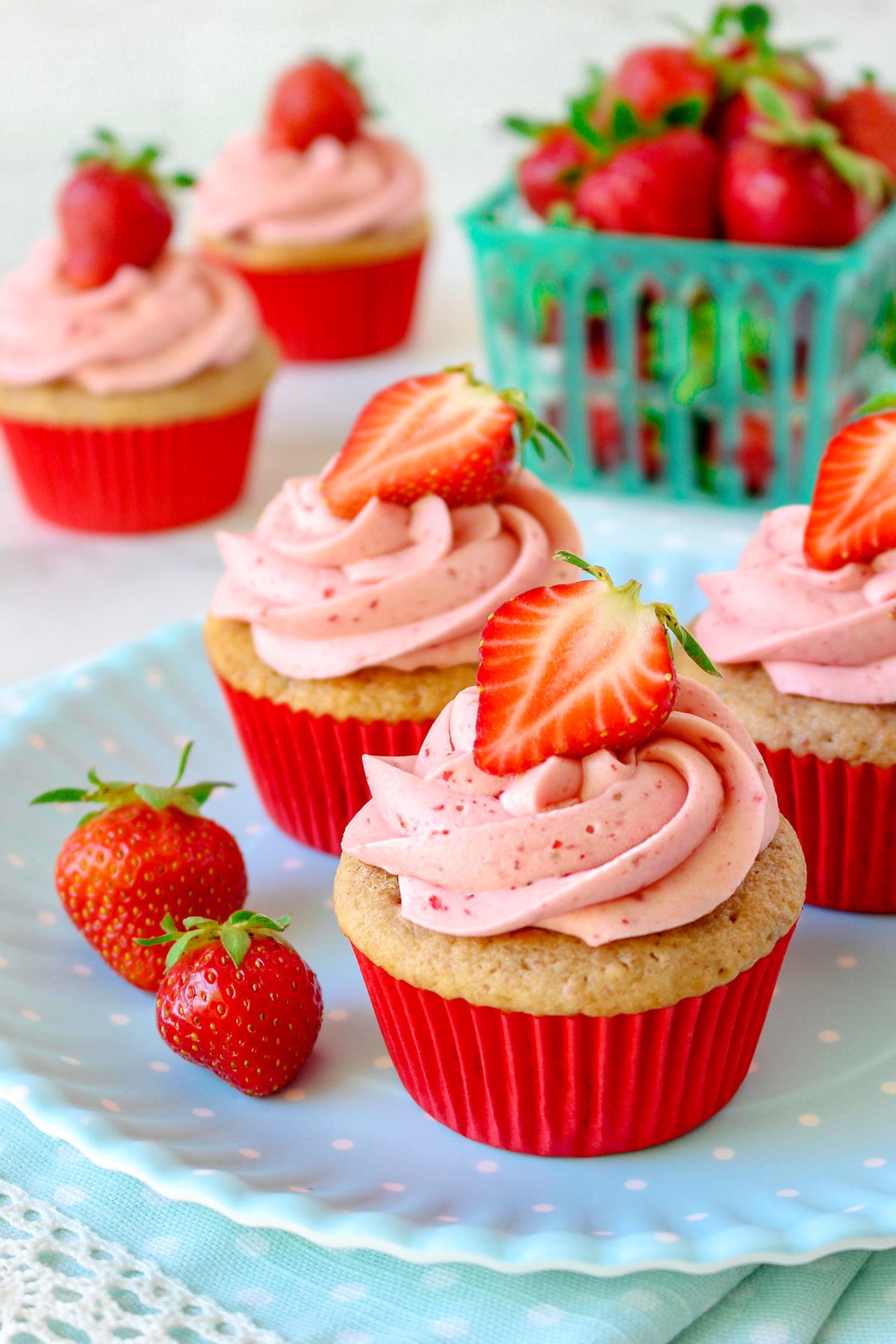 strawberry cupcake recipe on cooling rack with strawberry frosting and title overlay