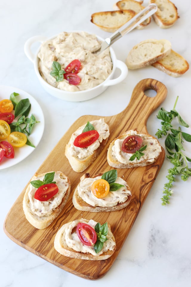 onion dip served on crostini garnished with tomato and basil