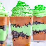 chocolate mint layered dessert in small square plastic cups.