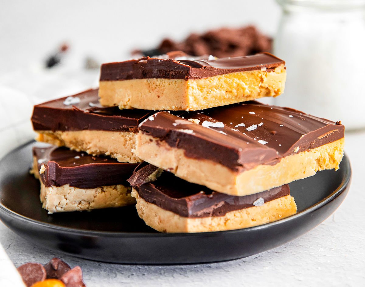 close up look at peanut butter chocolate bars on black plate stacked high.