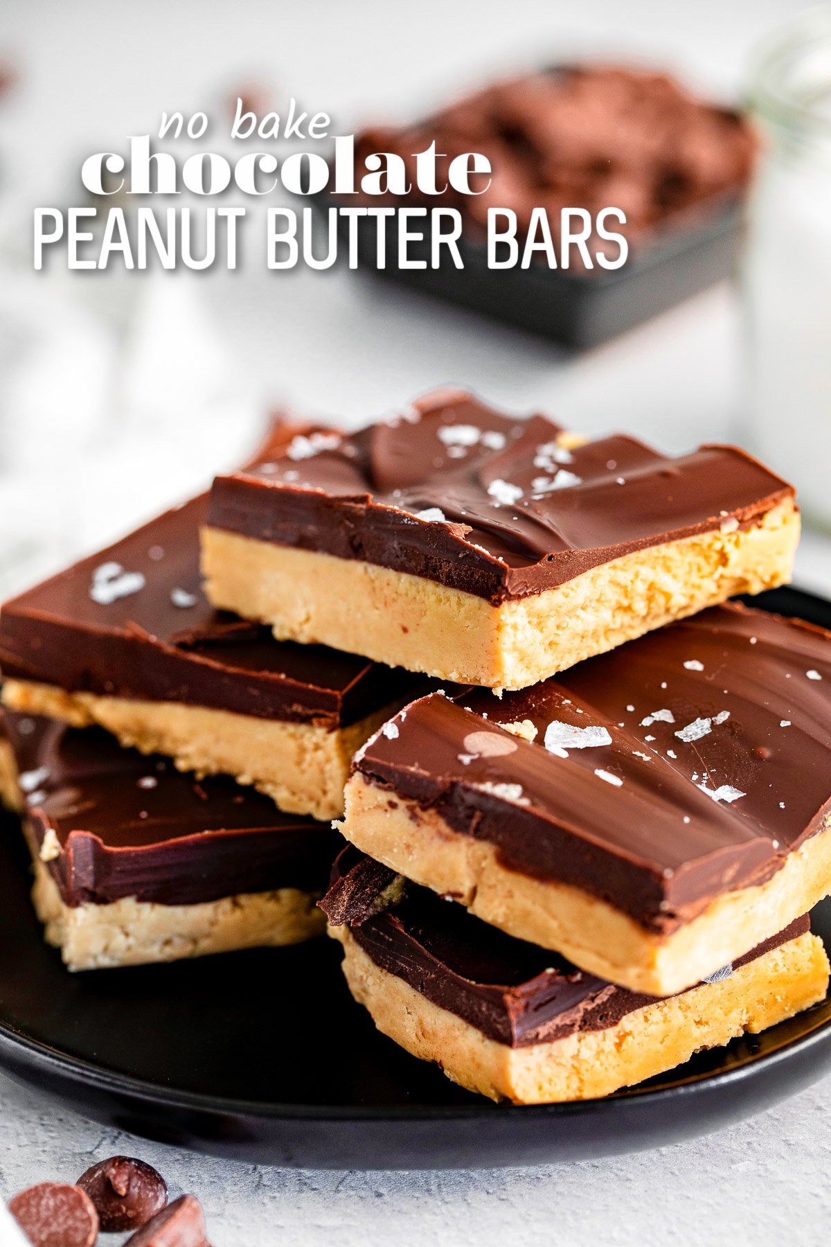 peanut butter chocolate bars stacked on black plate and sprinkled with sea salt. title overlay at top of image.