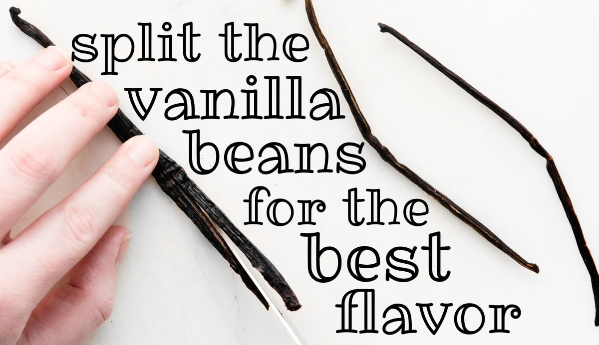 vanilla bean being cut in half on white cutting board.