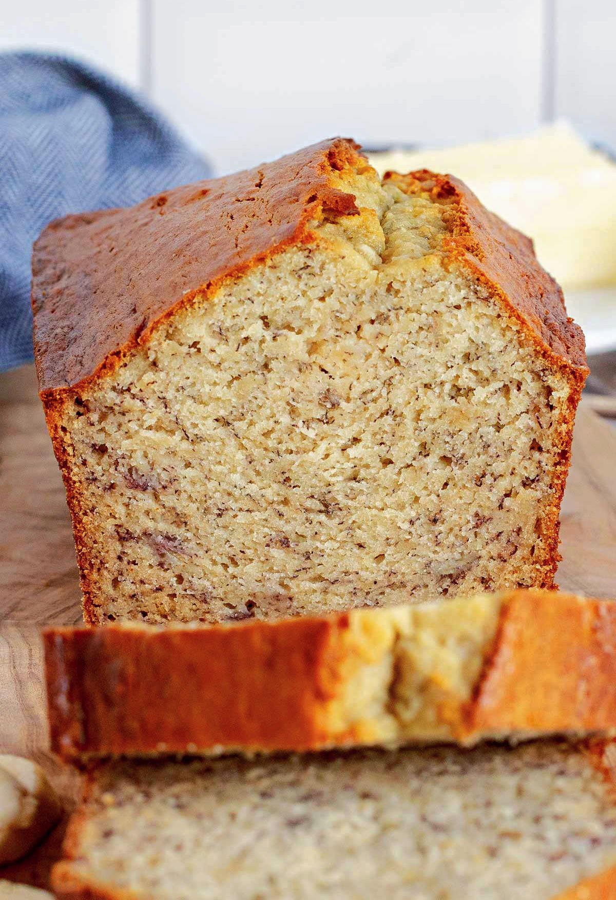 loaf of banana bread with two slices cut off and sitting in front of the bread loaf.