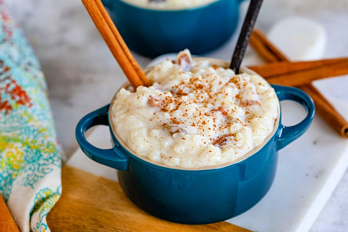 one bowl of rice pudding made with golden raisins and topped with cinnamon and a cinnamon stick.