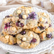 stack of cookies with blueberries and white chocolate chips on a white serving plate