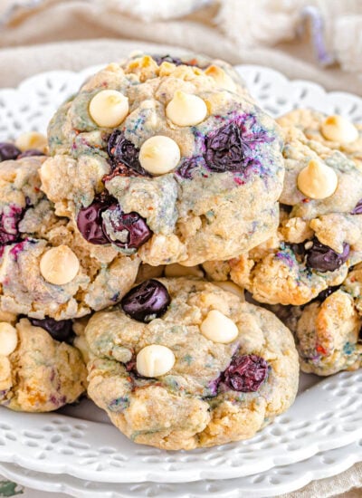 stack of cookies with blueberries and white chocolate chips on a white serving plate