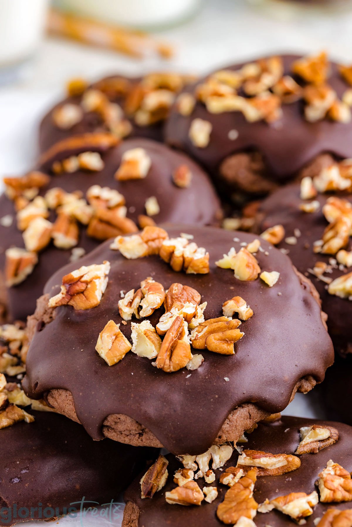 pile of texas sheet cake cookies topped with chocolate icing and pecans.