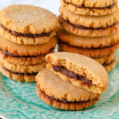 stacks of peanut butter cookies with chocolate filling. front stack's top cookie has been torn in half.